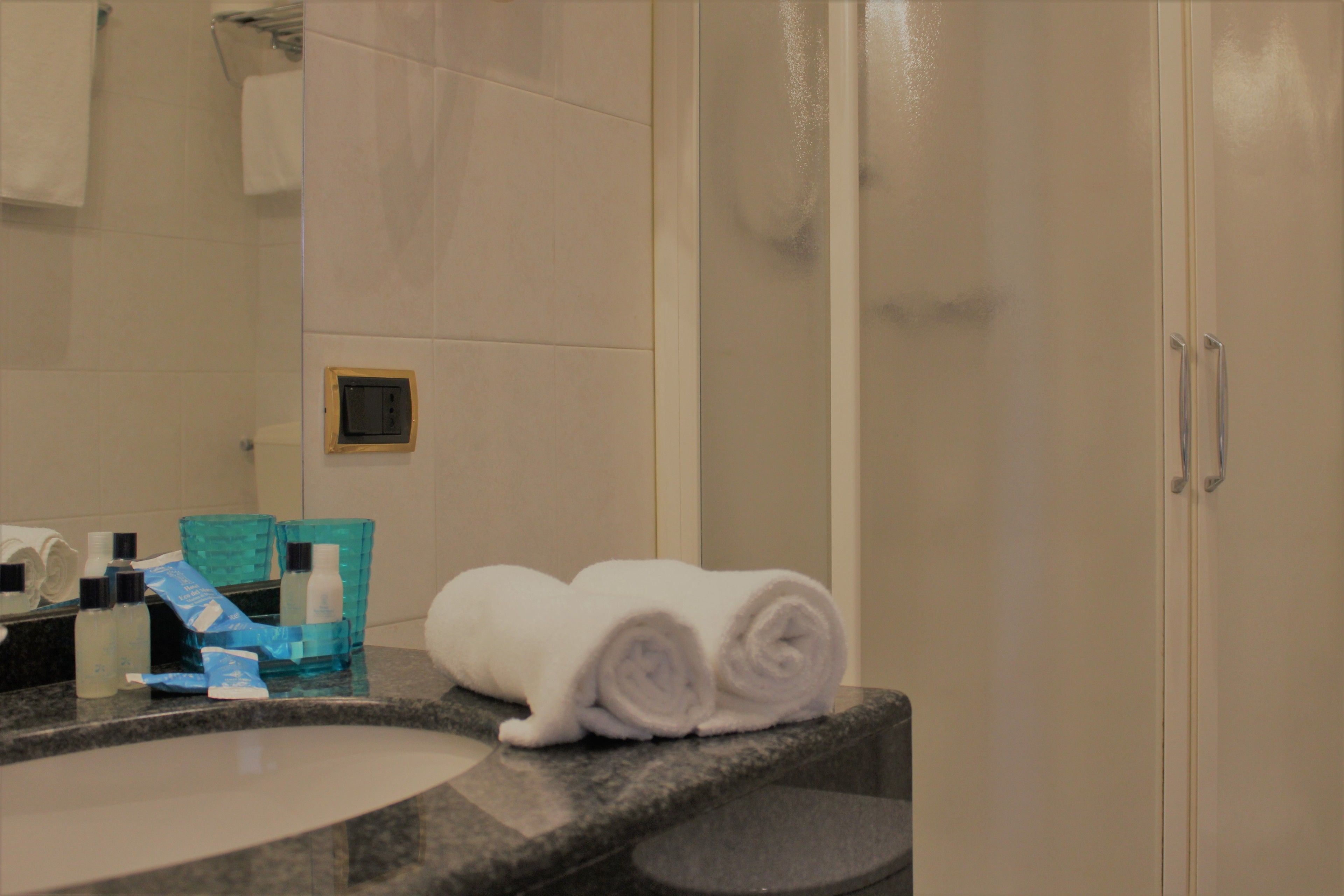 Ein Badezimmer mit Waschbecken, Spiegel und Handtuchhalter.