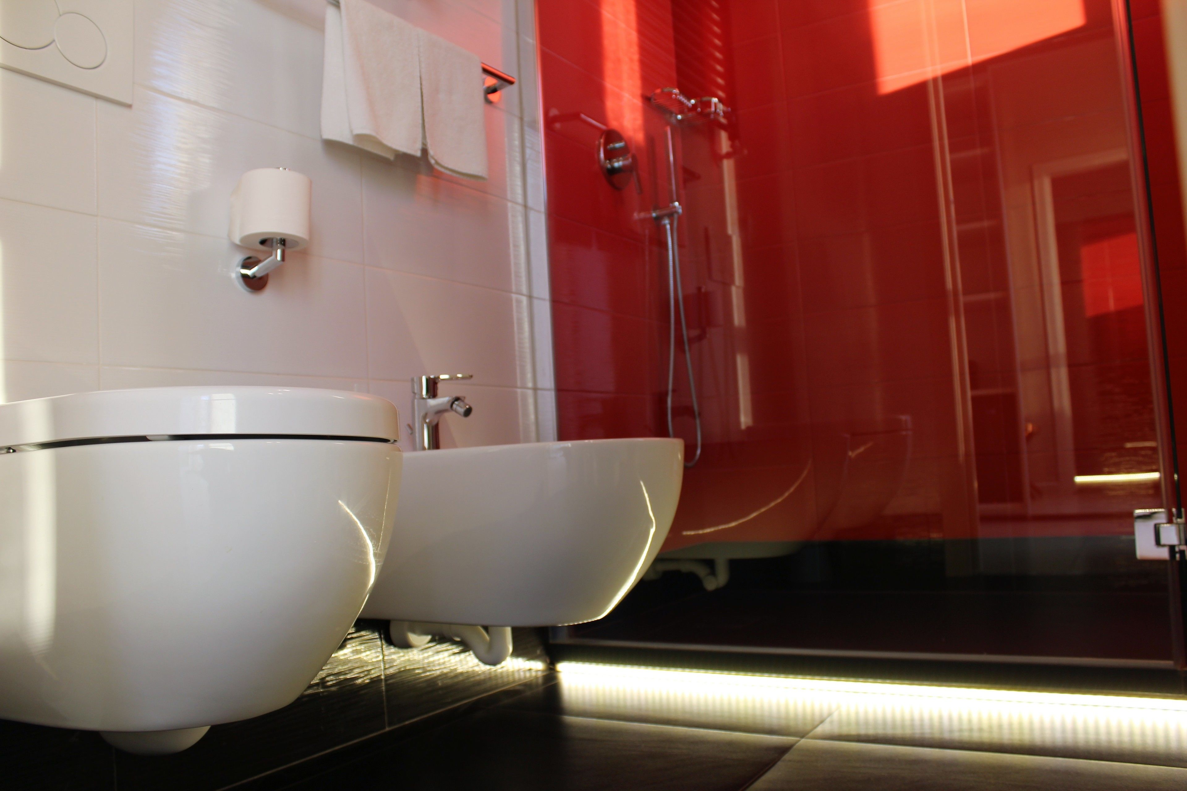 Une salle de bain moderne avec deux lavabos blancs, des toilettes et une douche.