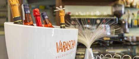 A bar area with a white container labeled "VARASCHIN" holding several bottles of champagne.