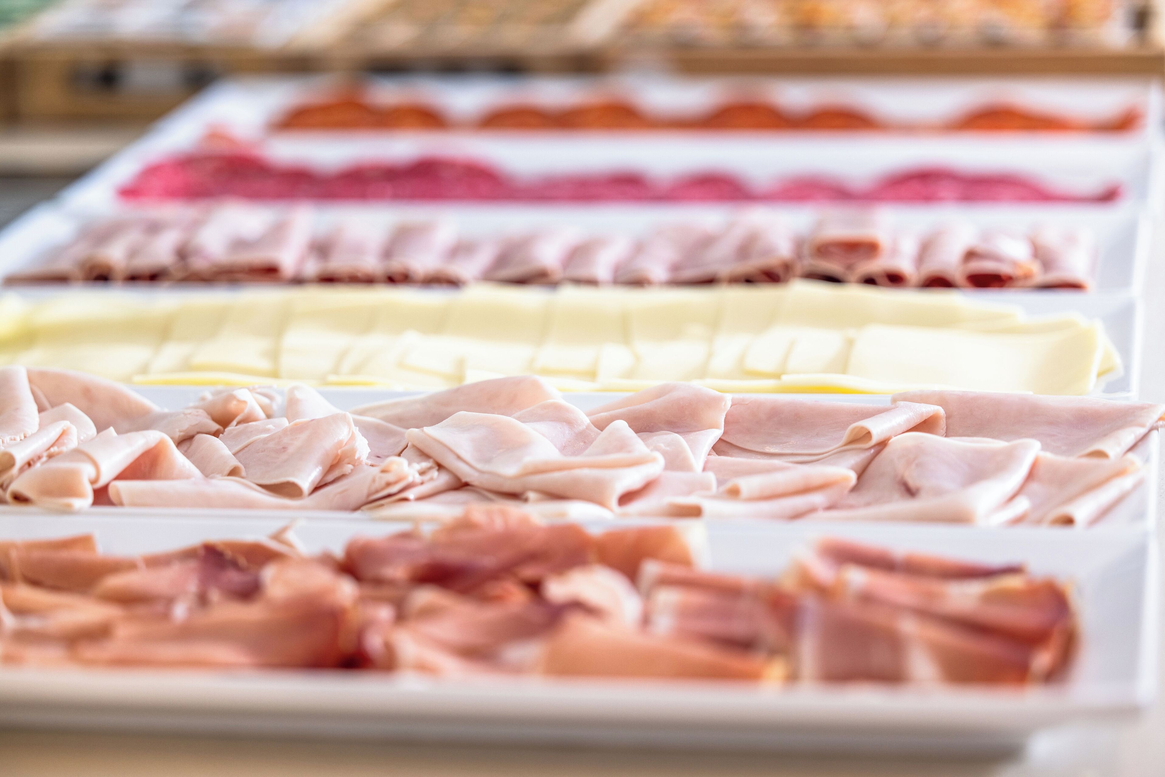 Diversas rebanadas de carne expuestas en bandejas.