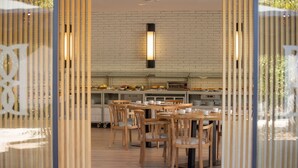 A modern kitchen with wooden furniture and a brick wall. - RVHotels Broquetas Spa Termal (Caldes de Montbui)