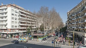 A multi-story residential building with balconies and a street in front. - De Guestibus (Rome)