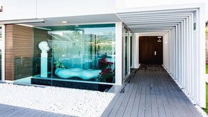 A modern building with a glass facade, a wooden deck, and a white exterior wall. - Seven Hotel & Wellness - Caters to Gay Men (San Bartolomé de Tirajana)