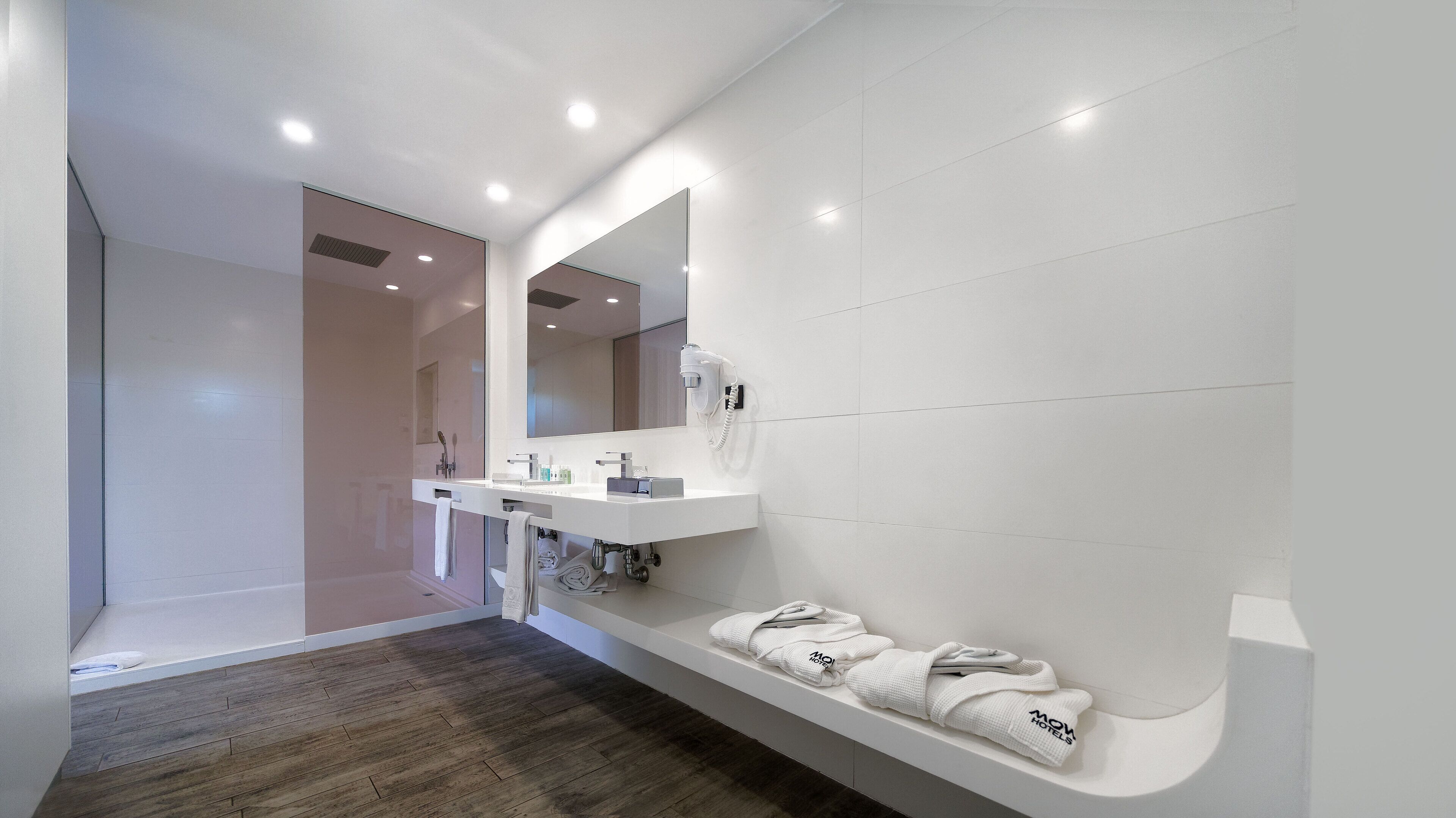 A modern bathroom with a white sink, mirror, and towel rack.