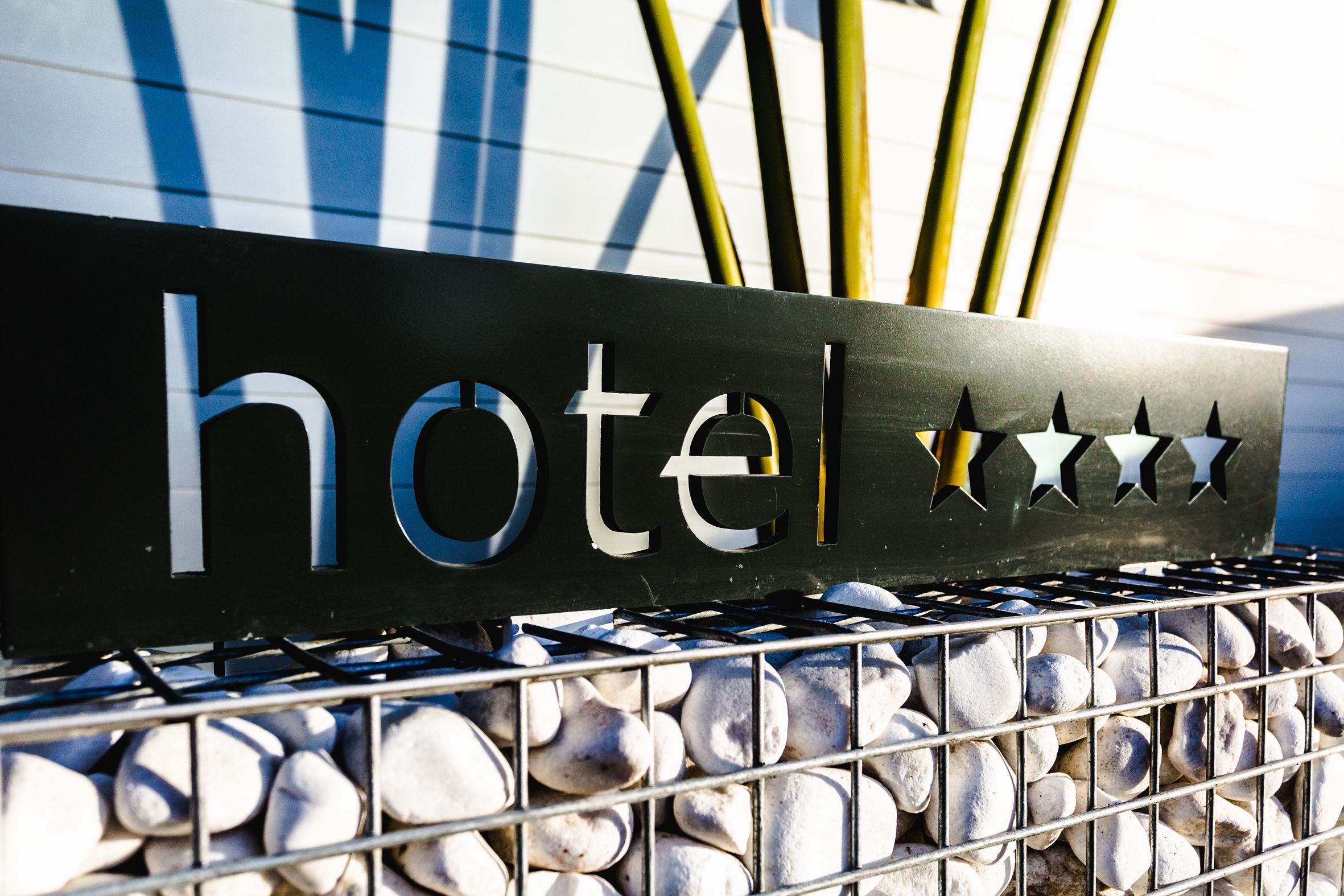Een hotelschild met daarop het woord 'hotel' en drie sterren.