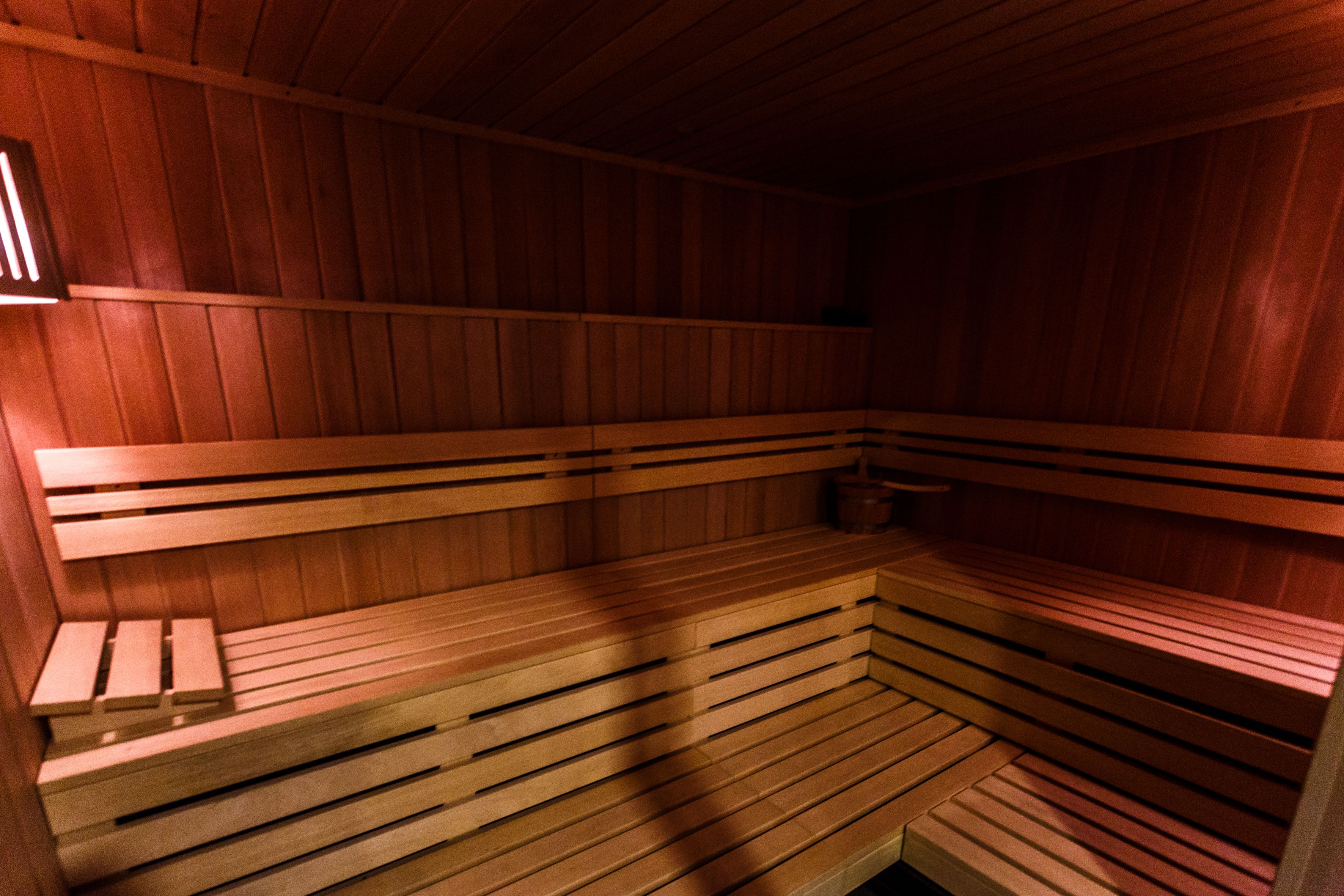 En sauna med træbænke og skråt gulv.
