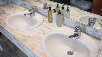 A bathroom with two sinks, a mirror, and toiletries.