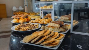 A buffet with various pastries and breads.