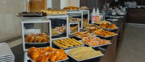Un buffet proposant une variété de produits de boulangerie et de pâtisserie.