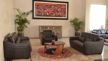 A living room with two leather sofas, a coffee table, a fireplace, and a large framed painting on the wall.