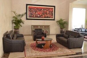 A living room with two leather sofas, a coffee table, a fireplace, and a large framed painting on the wall.