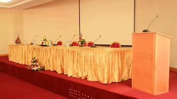 A conference room with a long table, microphones, and a podium.