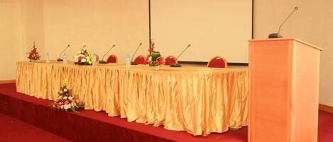 A conference room with a long table, microphones, and a podium.