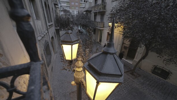 A narrow alley with ornate street lamps and buildings on either side. - Hostal ByBSiglo (Santiago)