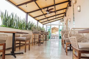 A covered outdoor seating area with wicker furniture and a ceiling fan.
