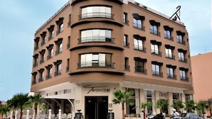A multi-story hotel with a curved facade, balconies, and a sign for 'Tempoo Hotel'.