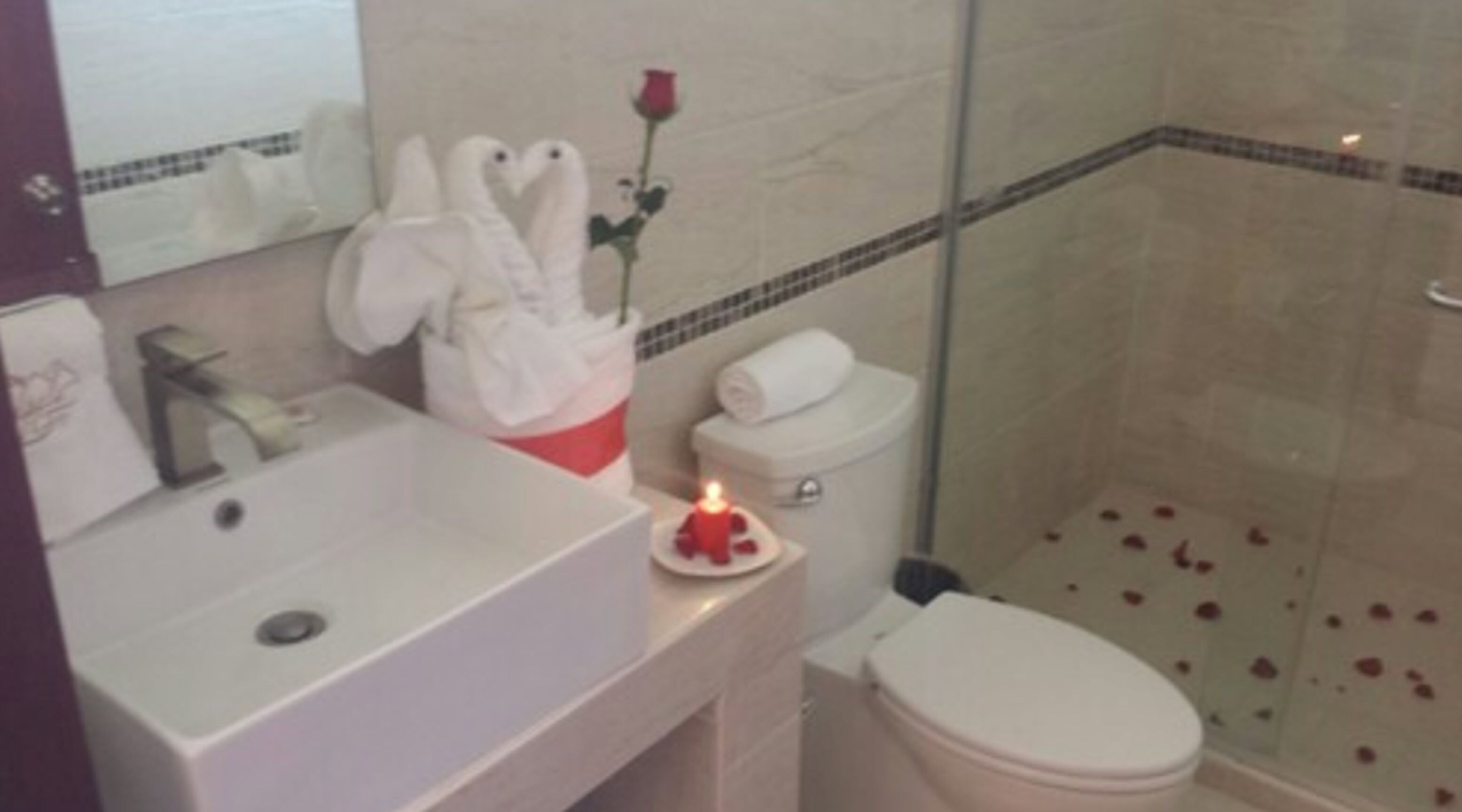 A bathroom with a sink, toilet, and shower.