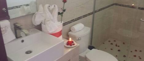 A bathroom with a sink, toilet, and shower.