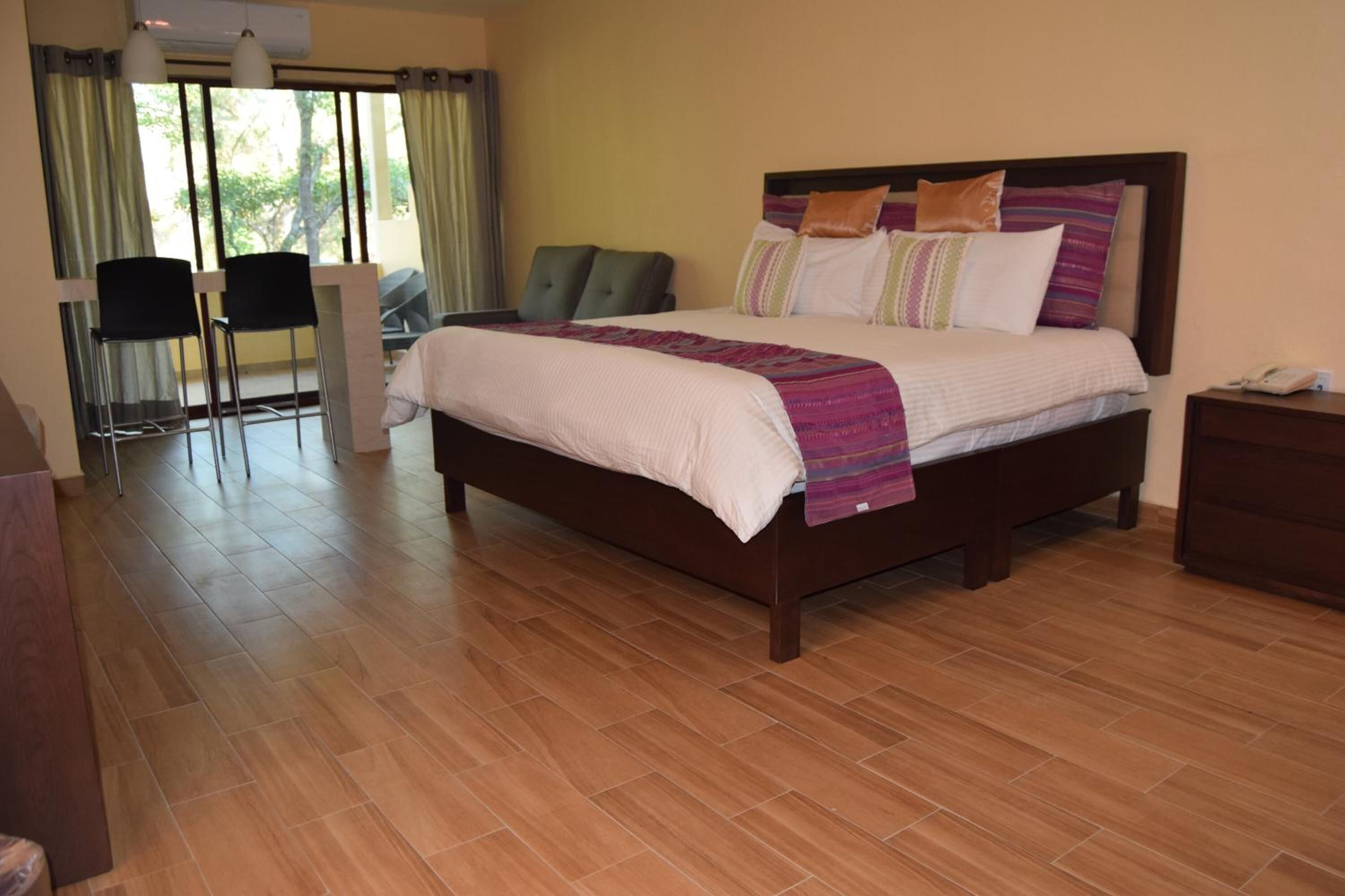 Una habitación de hotel con una cama grande, un escritorio y una silla.
