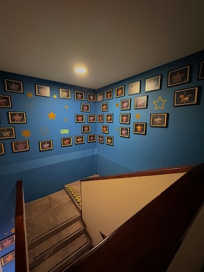 A staircase with a blue wall adorned with framed star awards.