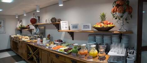 Ein reichhaltiges Buffet mit verschiedenen Speisen, Getränken und Besteck.