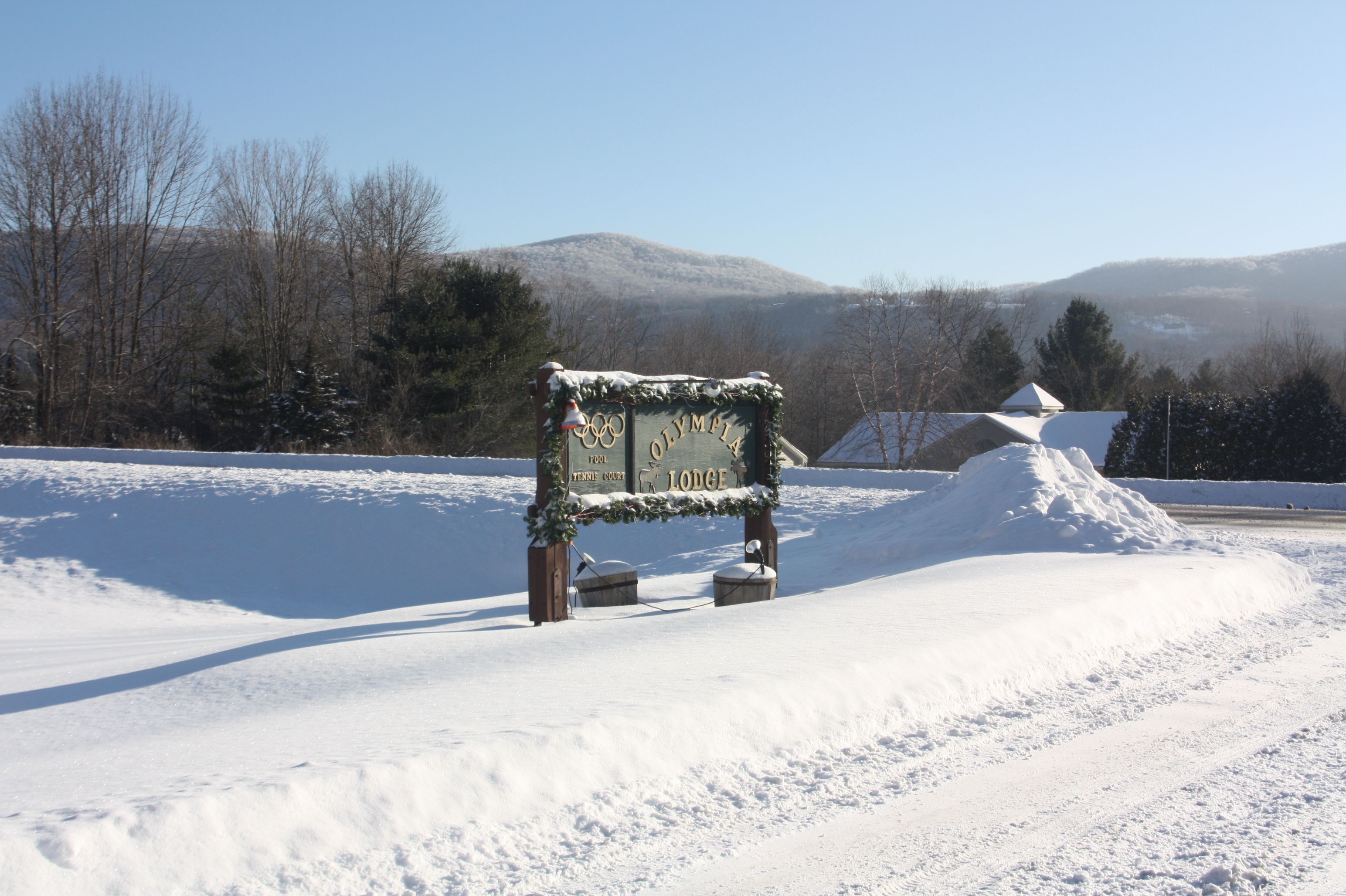 A snow-covered landscape with a sign indicating a lodge.