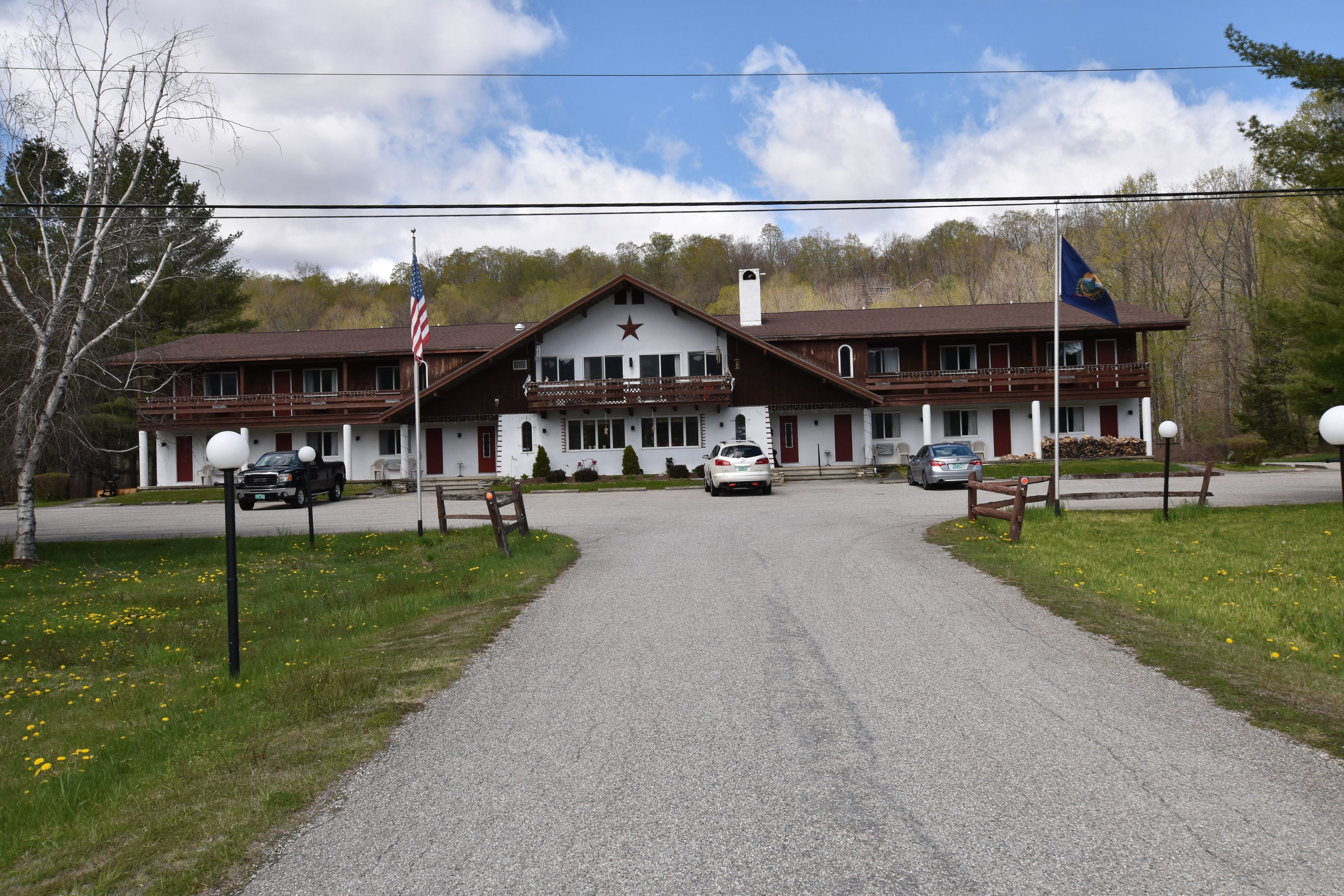 A two-story building with a central entrance, a flagpole with an American flag, and another flag.