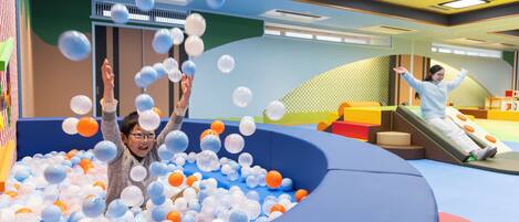 Un espace de jeux avec une piscine à balles et des toboggans.
