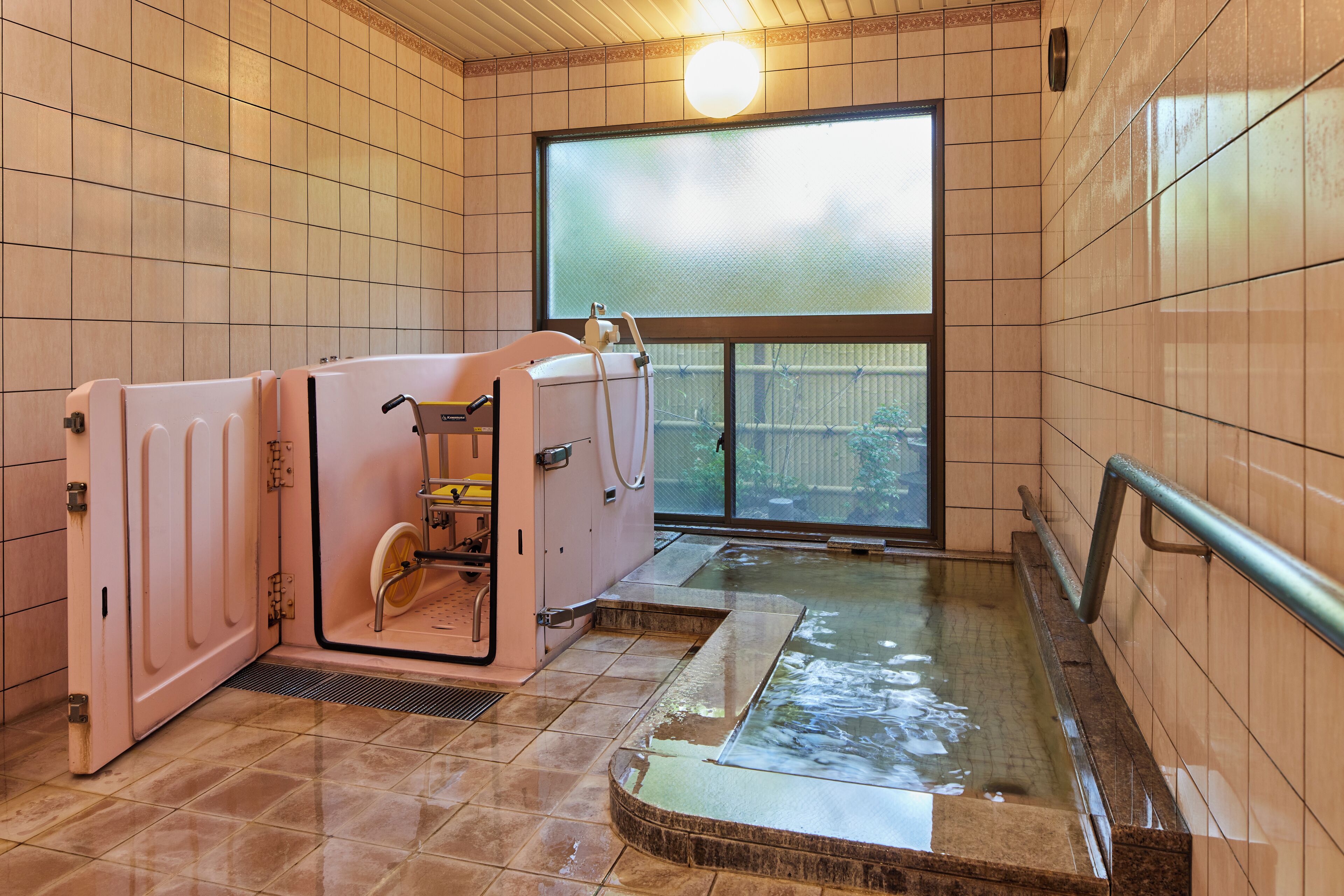 Una sauna con pavimento piastrellato, una panca e una finestra con vista all'esterno.