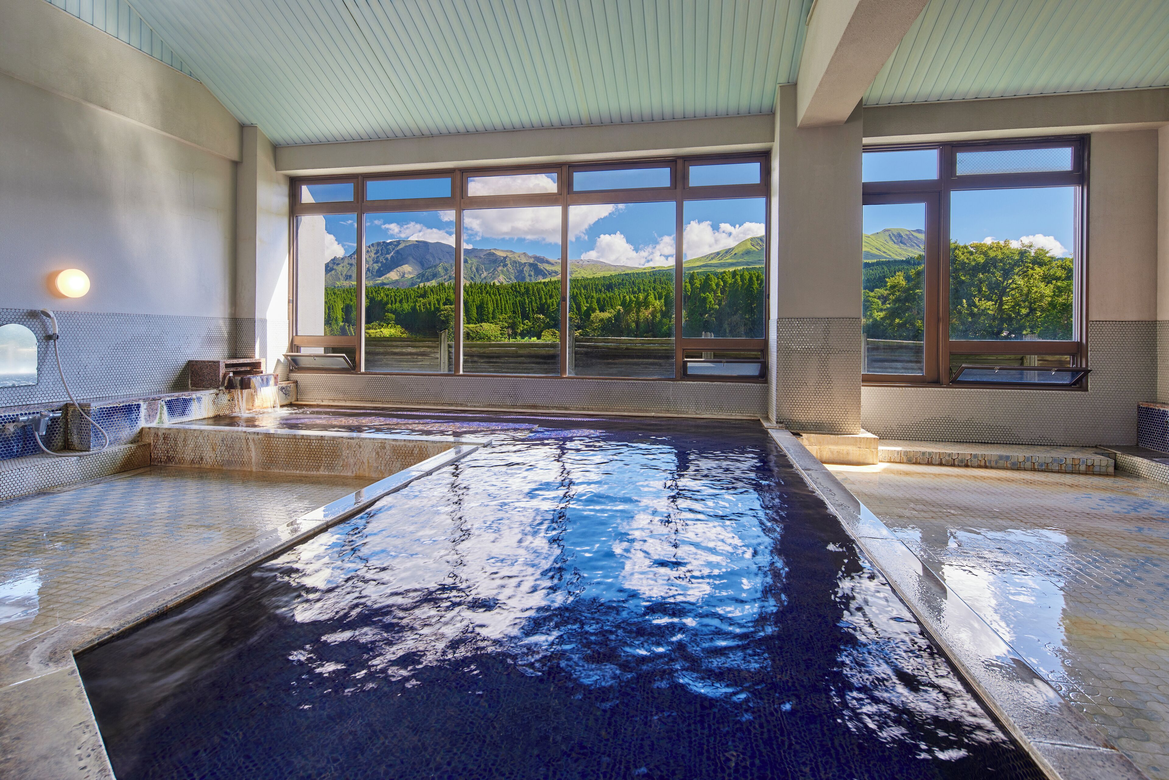 A large indoor swimming pool with clear windows offering mountain views.