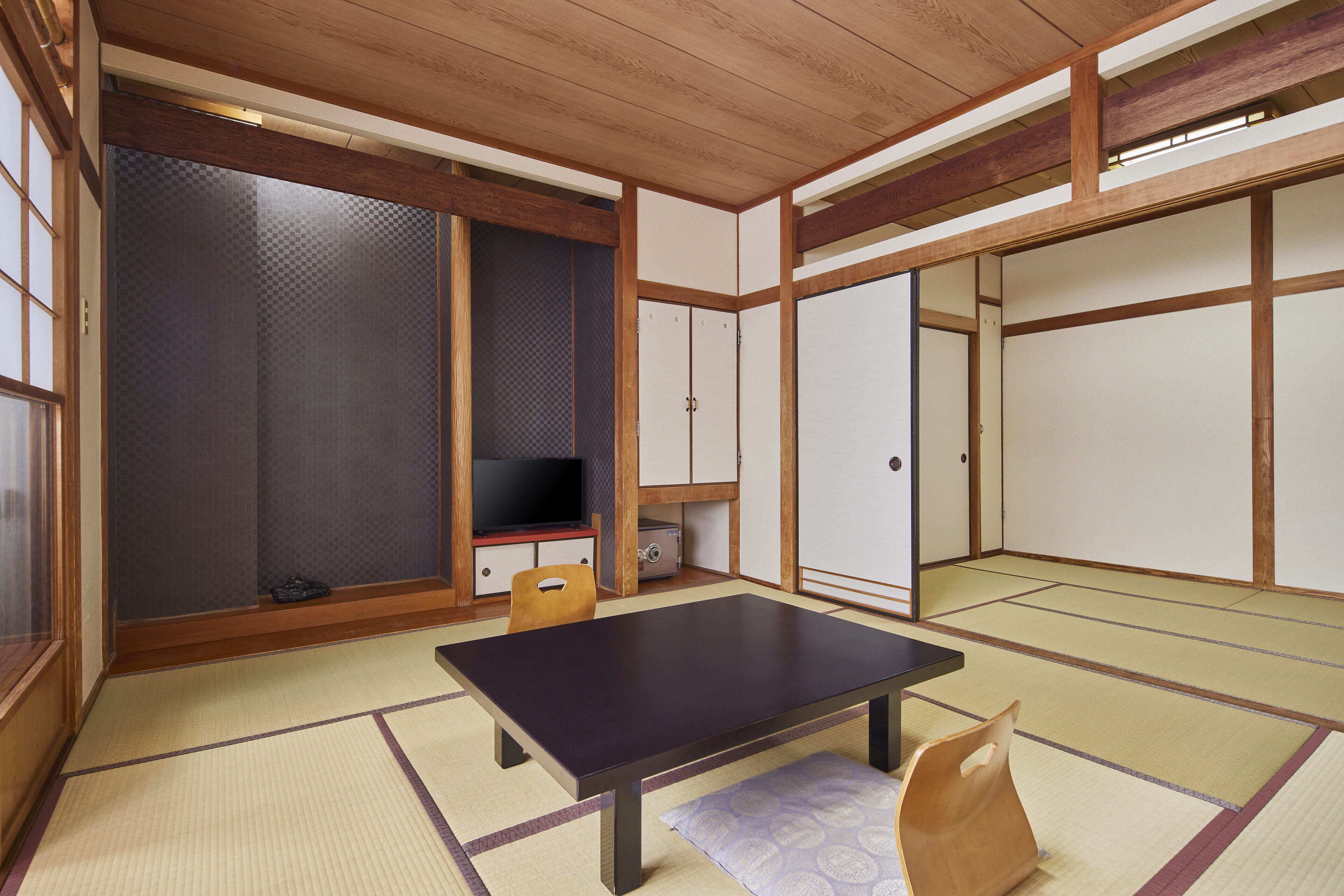 Una habitación japonesa tradicional con suelo de tatami, una mesa baja y puertas correderas.