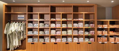A clothing store with shelves of folded garments and a rack of hanging clothes.