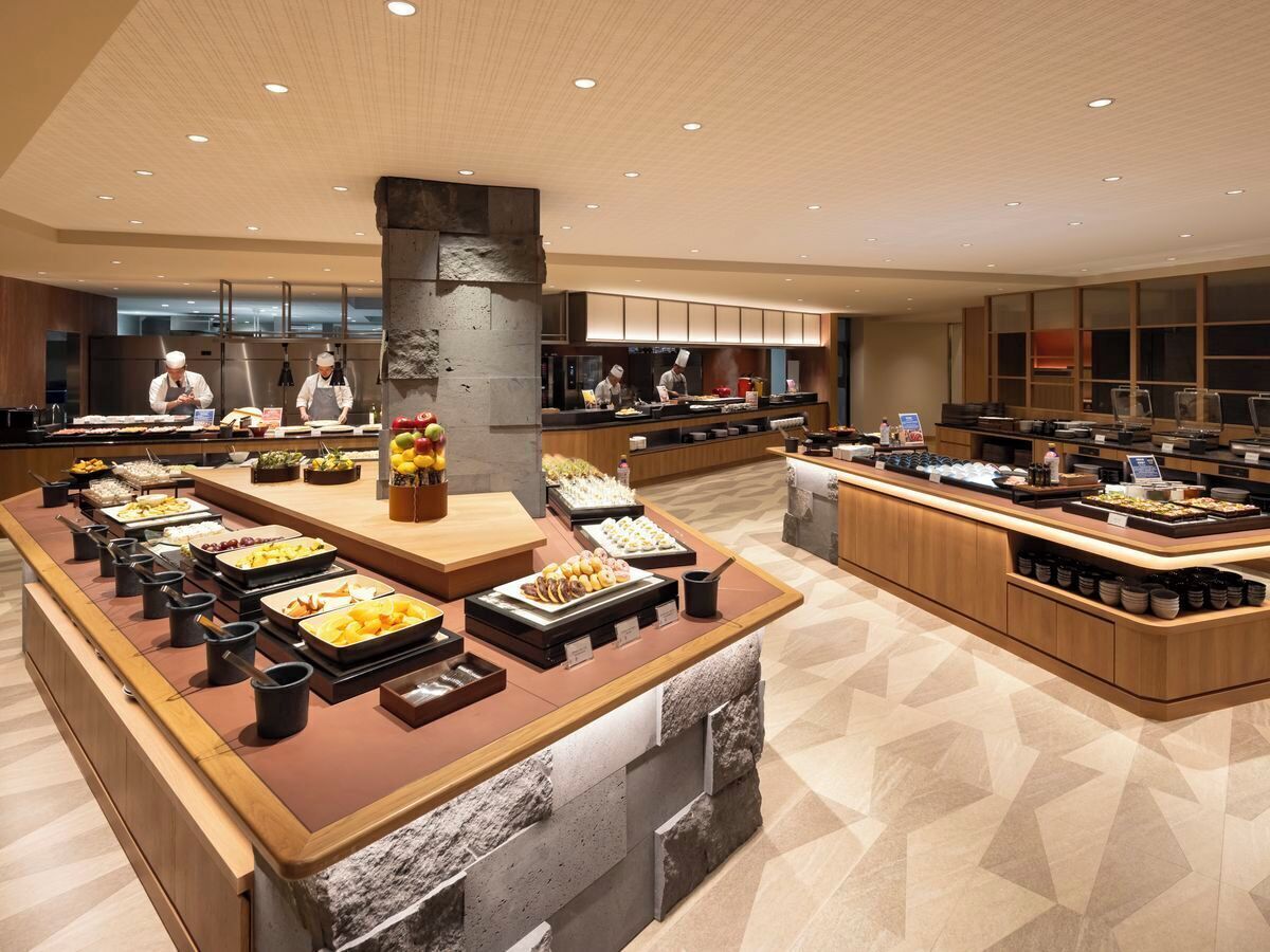 Un área de bufé con varias estaciones de comida y un alto pilar de piedra.