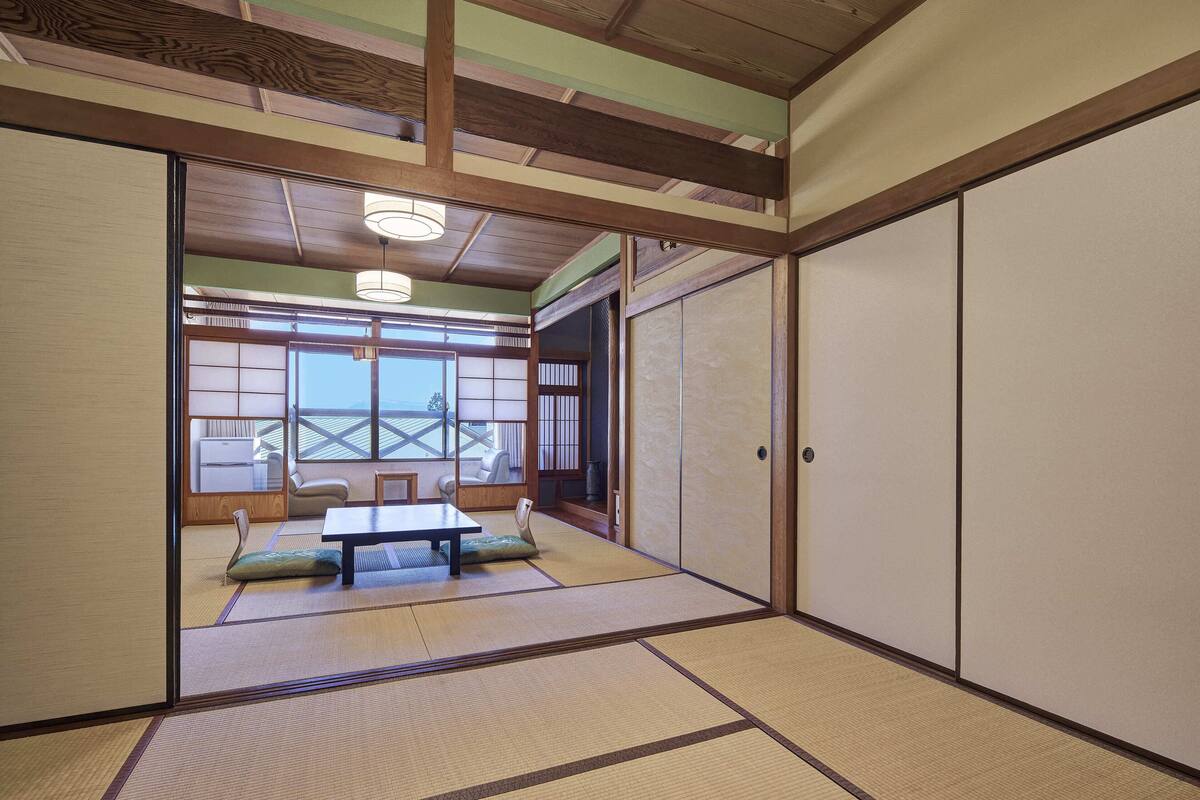 A traditional Japanese room with tatami flooring, sliding doors, and a low table.