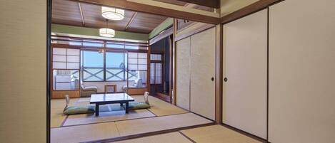 A traditional Japanese room with tatami flooring, sliding doors, and a low table.