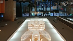 A modern interior with a central light fixture and a glass partition. - Hotel Nagano Avenue (Nagano)