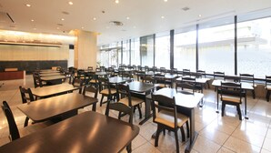 A spacious dining area with multiple tables and chairs, large windows offering a view of the outside, and a modern ceiling design with recessed lighting. - Hotel Nagano Avenue (Nagano)