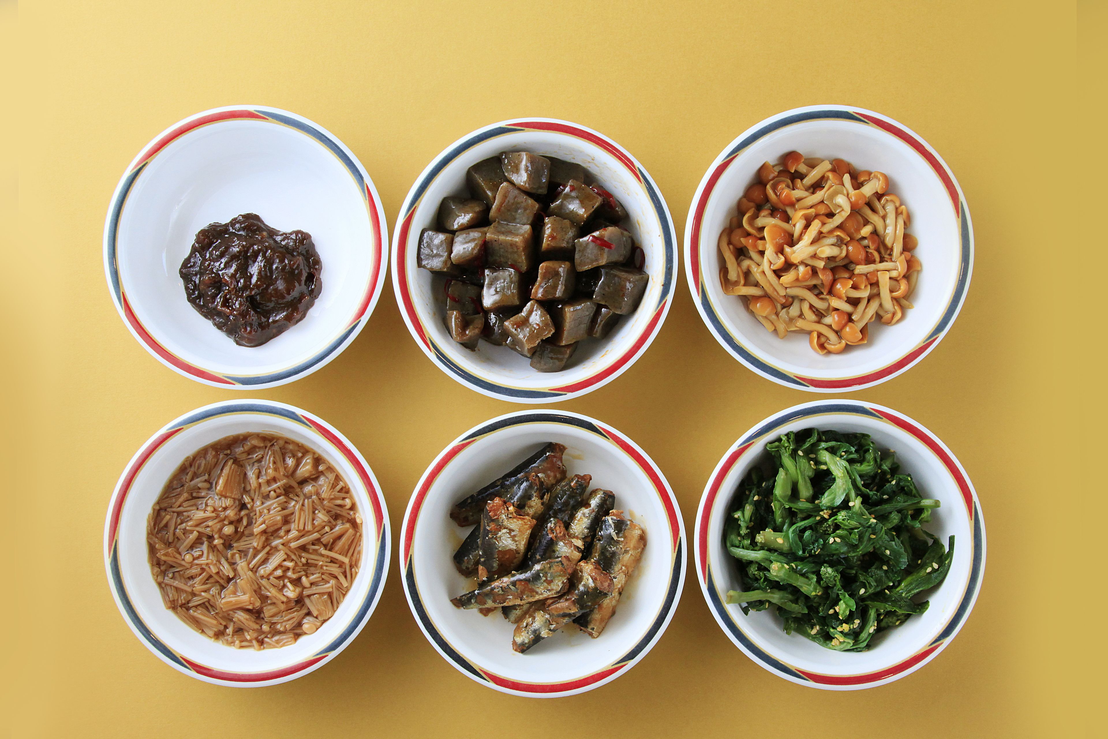 Six bowls of food on a yellow background.