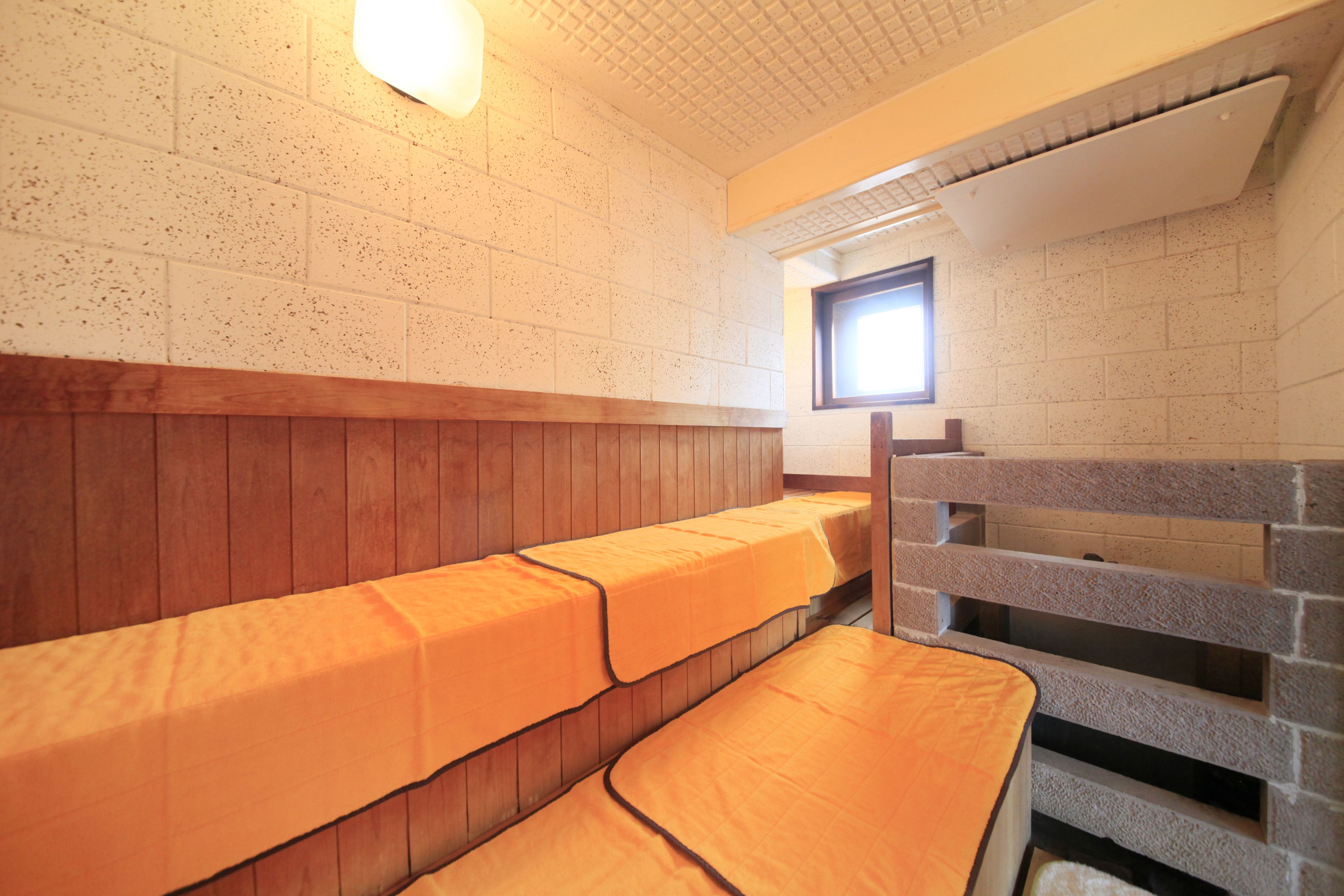 Une pièce avec des bancs en bois et une fenêtre.