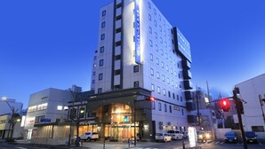 A multi-story hotel with a prominent entrance and a clear sky. - Hotel Nagano Avenue (Nagano)