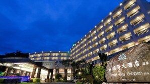 A multi-story hotel with a well-lit facade, a large sign with the hotel's name, and a paved entrance area. - Hotel Royal Chihpen (Taimali)