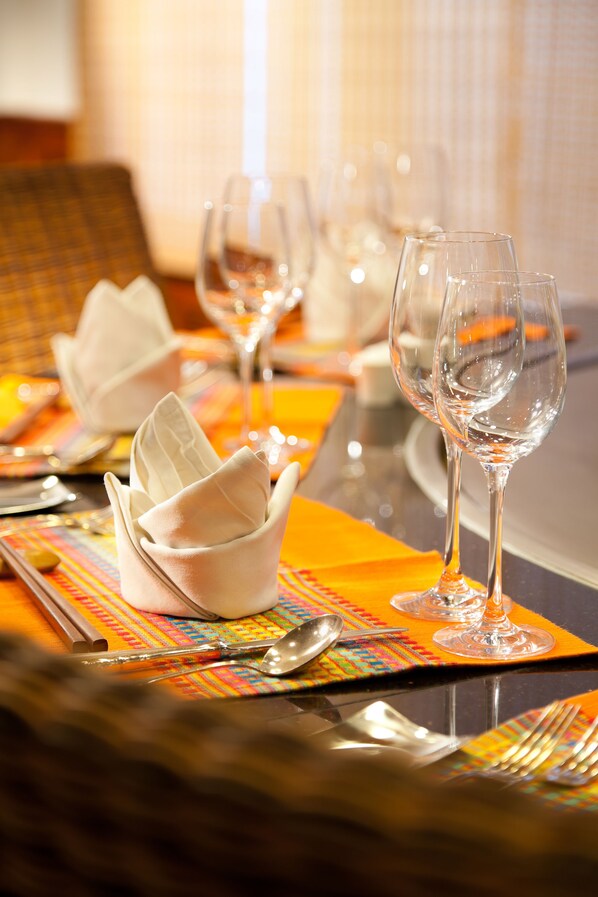 Una mesa vestida con servilletas blancas, copas de vino y cubiertos.