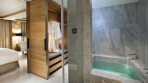 A modern hotel room with a walk-in closet, a glass shower enclosure, and a built-in bathtub. - Hotel Royal Chihpen (Taimali)