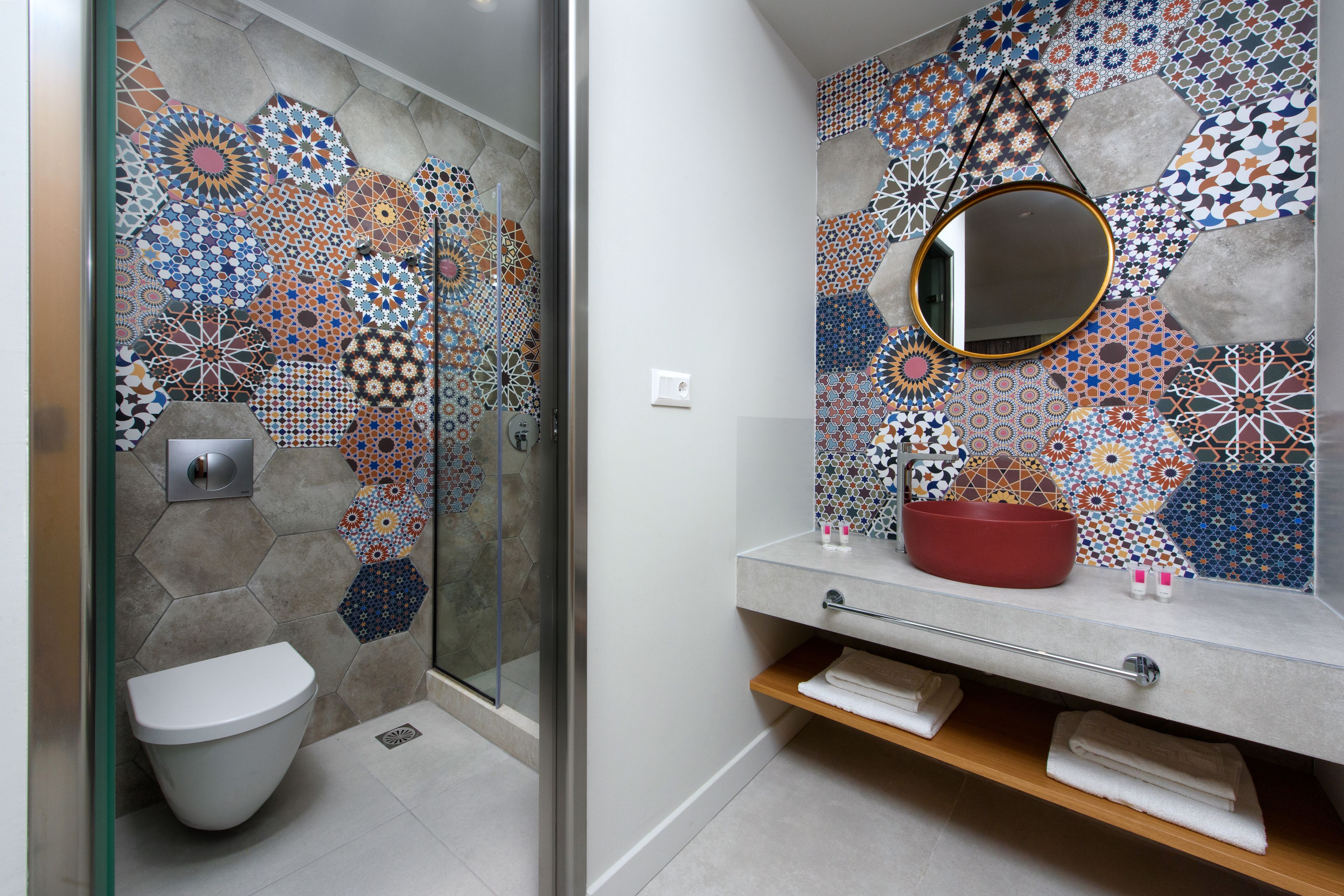 A bathroom with a shower, toilet, and sink with a mirror.
