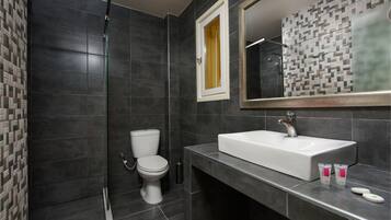 Un baño moderno con un lavamanos grande, un inodoro y una zona de ducha.