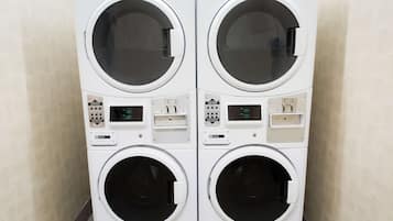 A pair of white, wall-mounted laundry machines with control panels and a digital display.