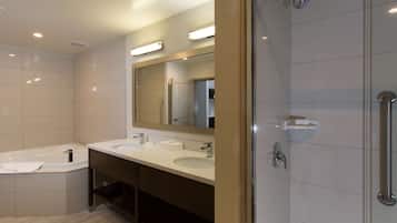 A modern bathroom with two sinks, a bathtub, and a walk-in shower.