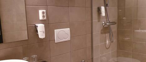 A modern bathroom with a toilet, sink, and glass-enclosed shower.