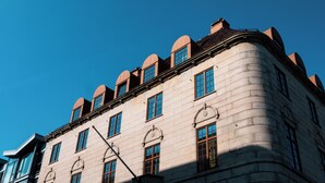 A historic building with a curved facade, multiple windows, and a prominent corner section. - Banken Hotel (Haugesund)
