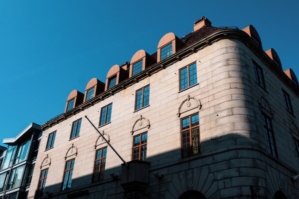 Un bâtiment historique doté d’une façade incurvée, de nombreuses fenêtres et d’une partie d’angle particulièrement saillante.